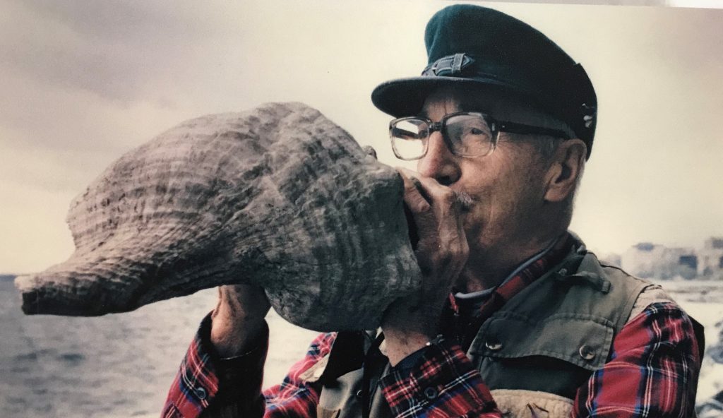 Art Hasler blowing into conch shell
