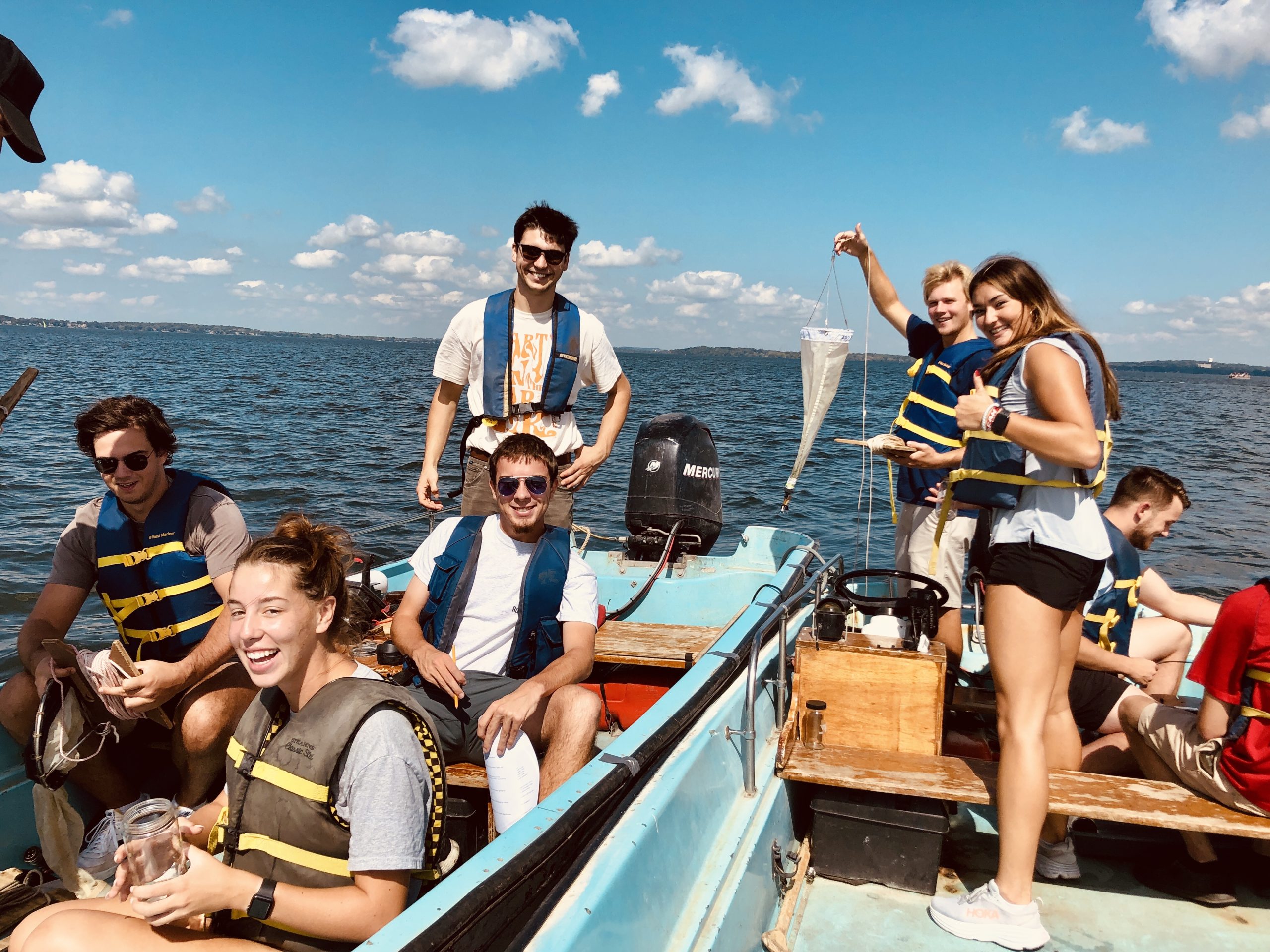 Seven undergraduate students in two Boston Whaler boats sampling water and zooplankton on Lake Mendota.