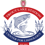 Trout Lake Station logo with drawing of a trout jumping out of water in the center and drawing of wild rice on left and right of fish. Words Trout Lake Station arching at top and Center for Limnology arching at bottom.